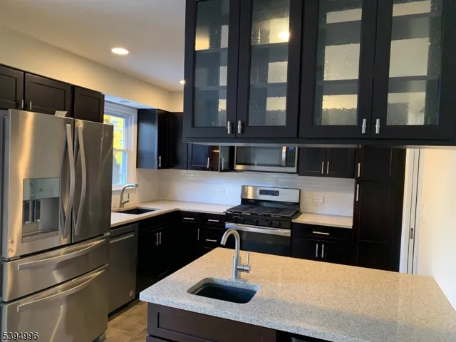 a kitchen with stainless steel appliances a sink stove and refrigerator