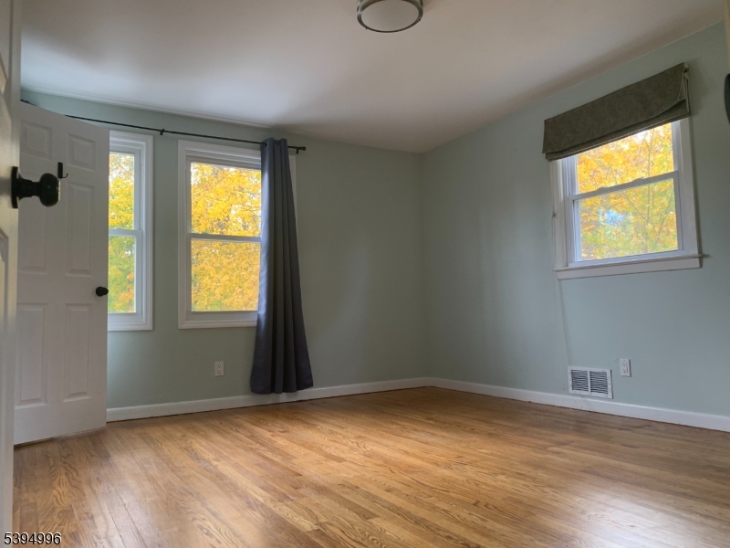 1072 Springfield Avenue New Providence, NJ 07974 - Photo 6 of 20 a view of an empty room with wooden floor and a window