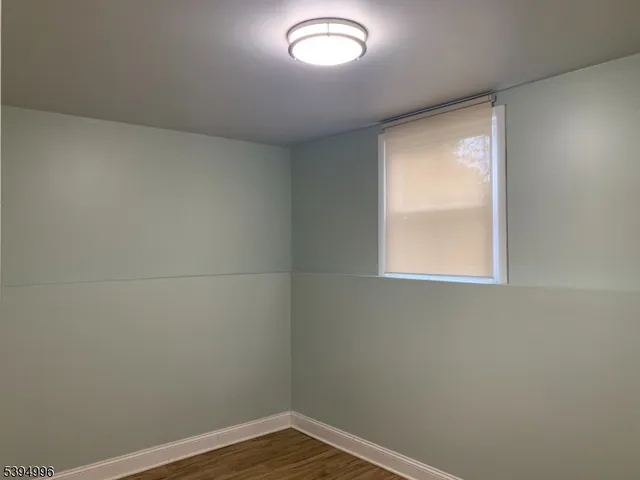 a view of a small space with wooden floor and a window