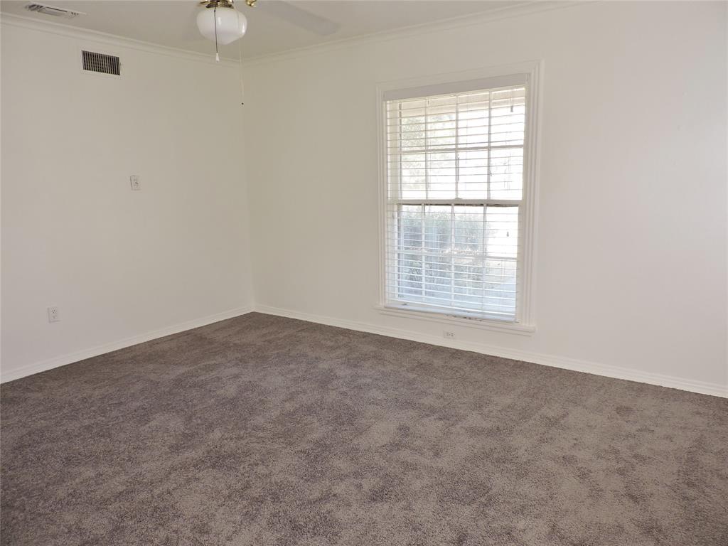 3425 Westcliff Road South Fort Worth, TX 76109 - Photo 11 of 22 Empty room featuring dark carpet, crown molding, and a ceiling fan