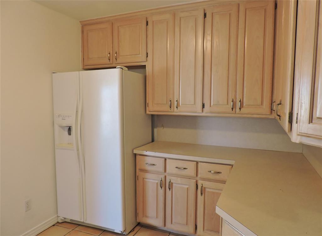 3425 Westcliff Road South Fort Worth, TX 76109 - Photo 5 of 22 Kitchen with white fridge with ice dispenser, light countertops, light brown cabinets, and light tile patterned floors