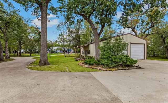 a front view of a house with a yard and trees