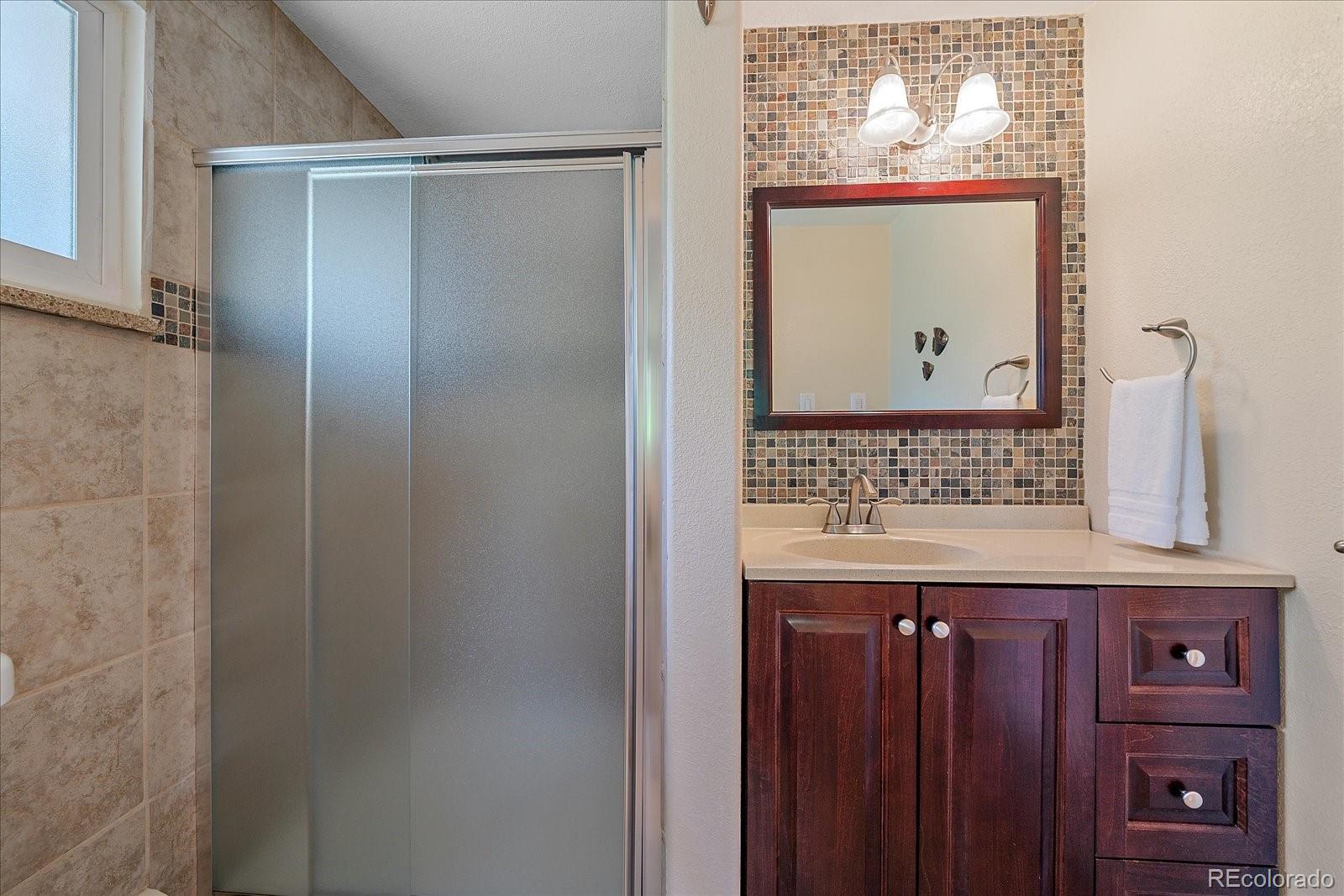 930 Reed Court Lakewood, CO 80214 - Photo 28 of 41 a view of bathroom with a sink and a mirror