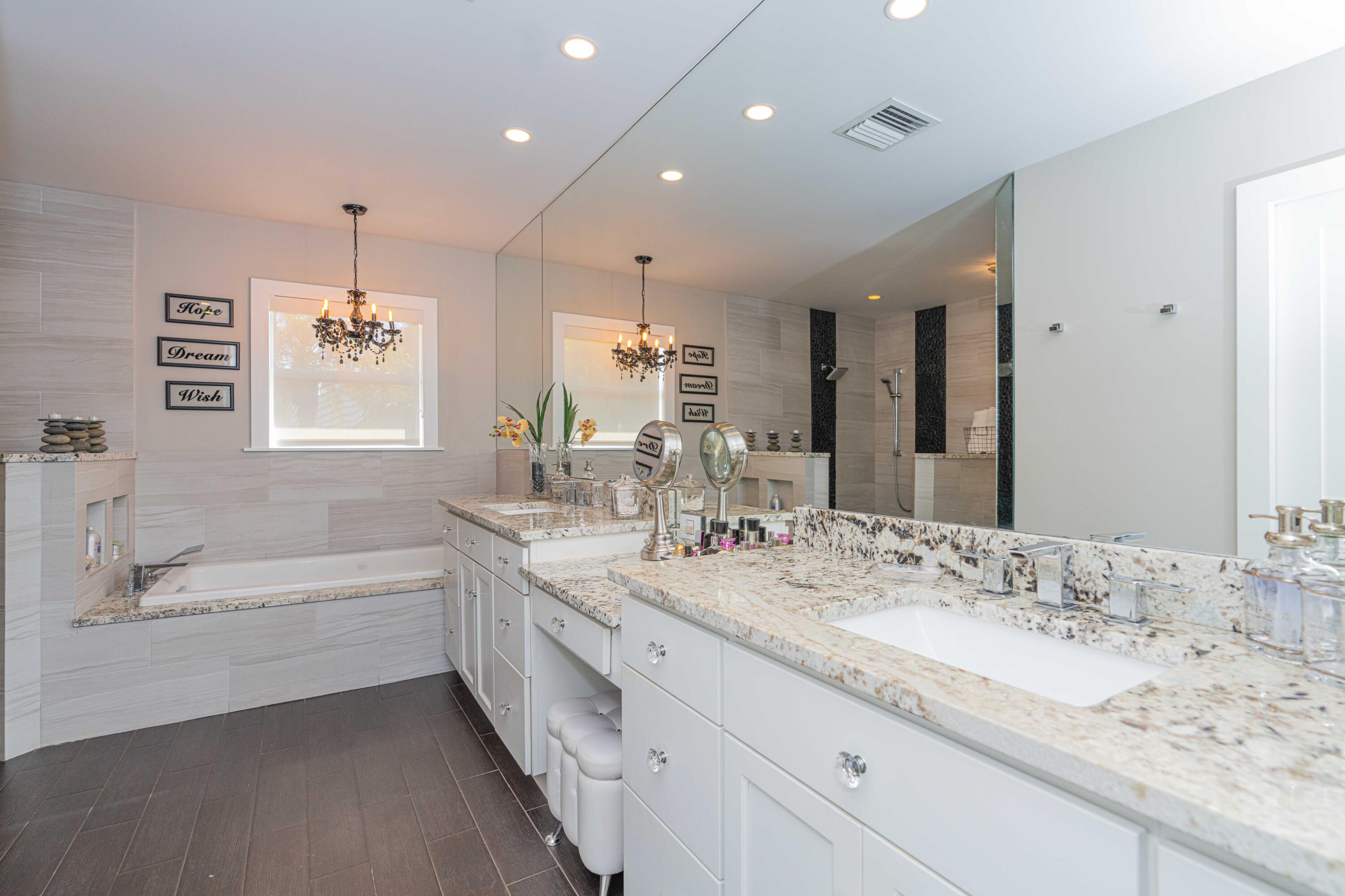 855 Berkley Street Boca Raton, FL 33487 - Photo 16 of 31 a bathroom with a granite countertop sink a large mirror and a bathtub