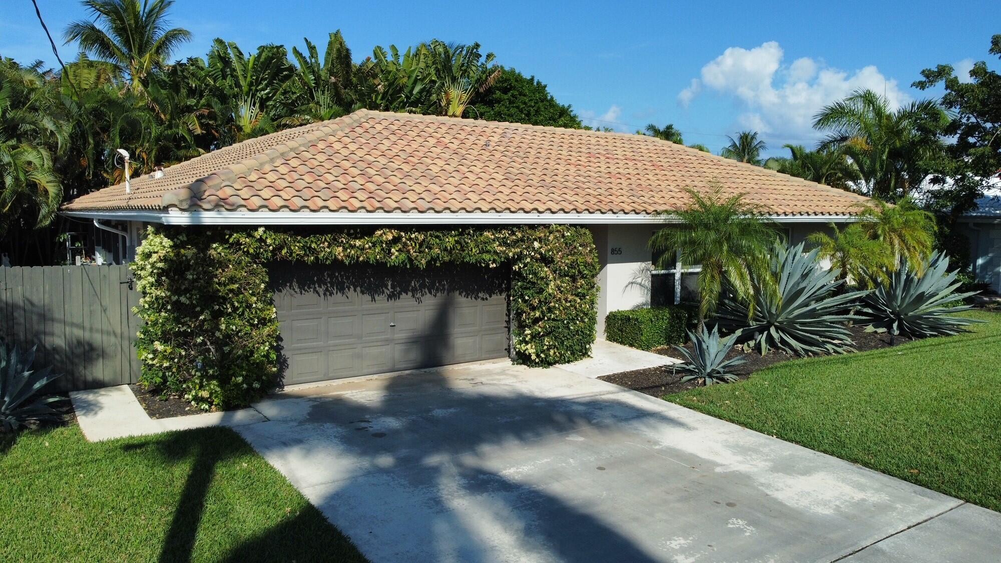 855 Berkley Street Boca Raton, FL 33487 - Photo 4 of 31 a view of a house with a yard and garage