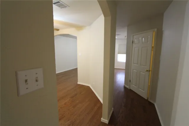 a view of an empty room with a chandelier fan