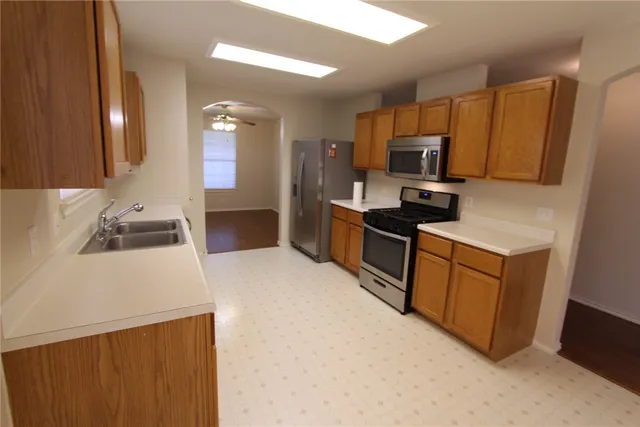 a kitchen with stainless steel appliances a sink stove and refrigerator