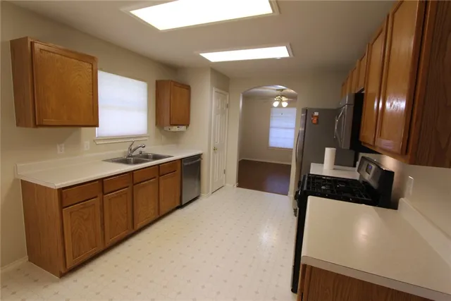 a large white kitchen with a sink and a large mirror