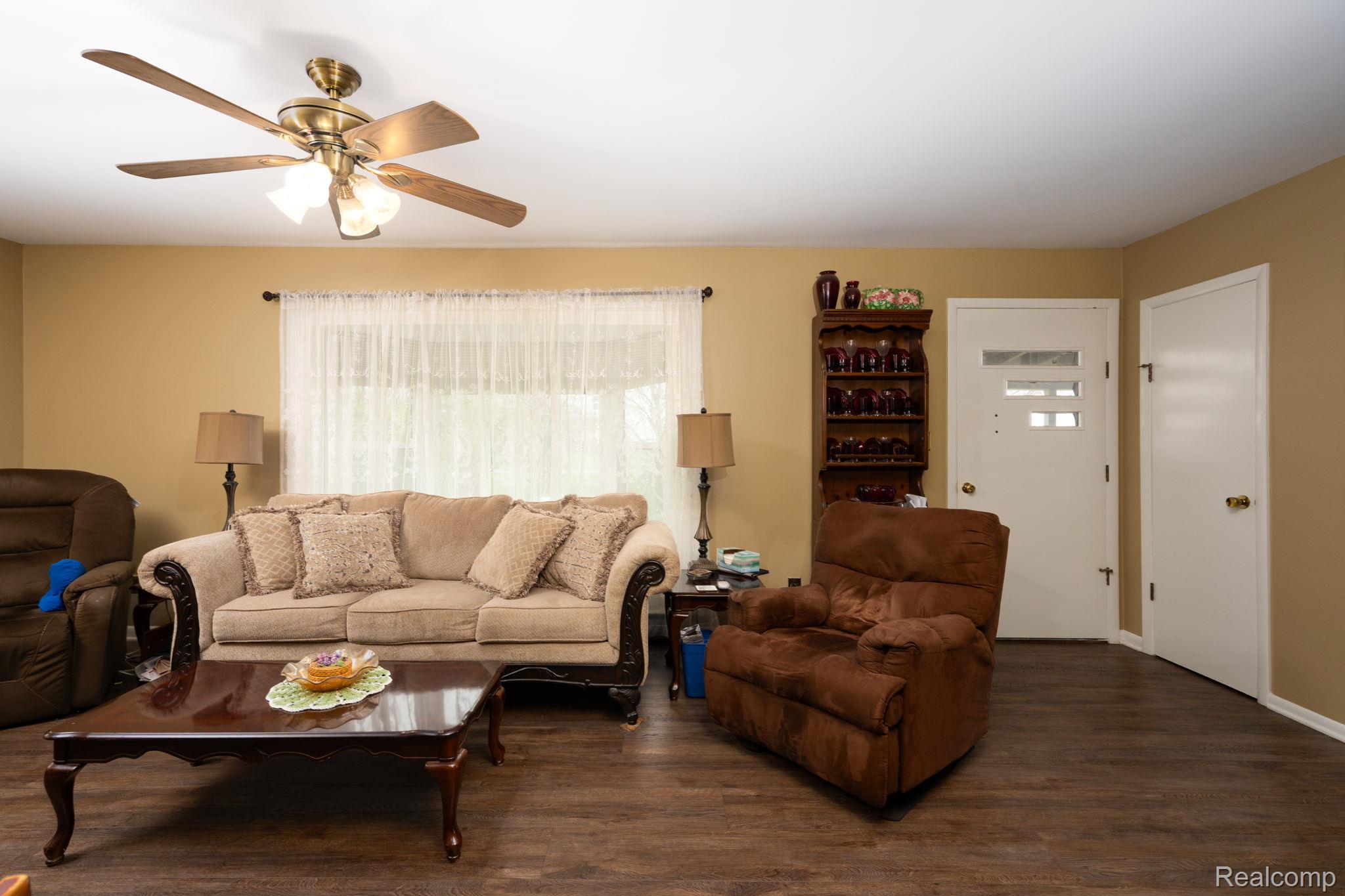 Living room with wood finished floors and a ceiling fan
