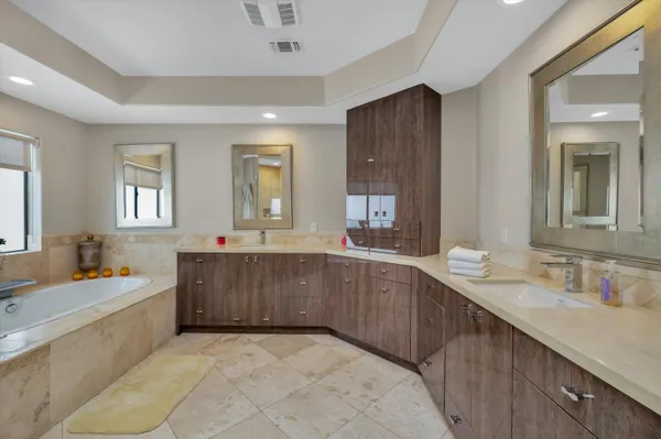 a bathroom with a tub sink and mirror
