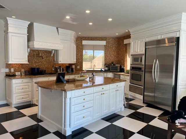 a kitchen with a checkered floor and white cabinets