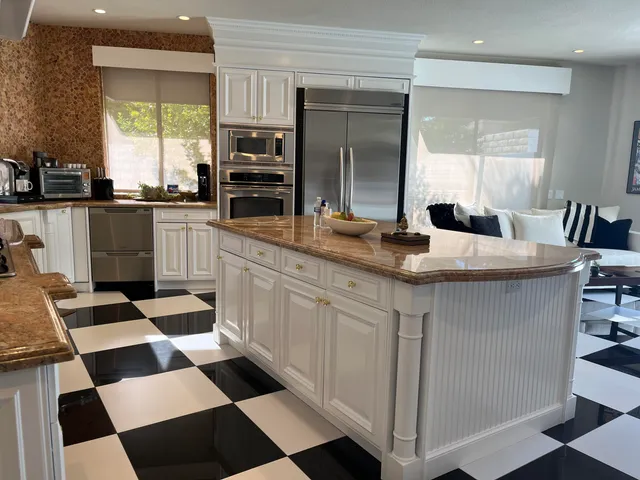 a kitchen with stainless steel appliances kitchen island granite countertop a sink and cabinets