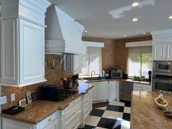a kitchen with stainless steel appliances granite countertop a sink stove and refrigerator