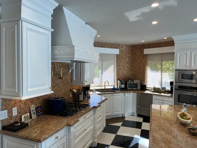 a kitchen with stainless steel appliances granite countertop a sink stove and refrigerator