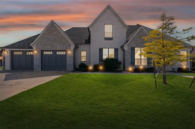 a front view of a house with a yard and trees