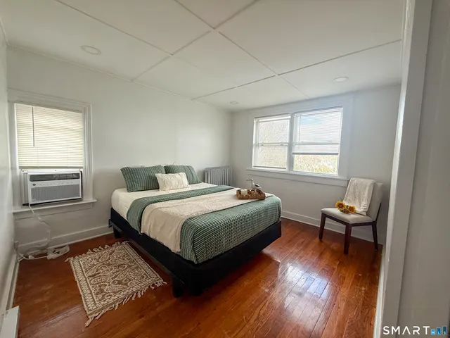 a bedroom with a bed and wooden floor