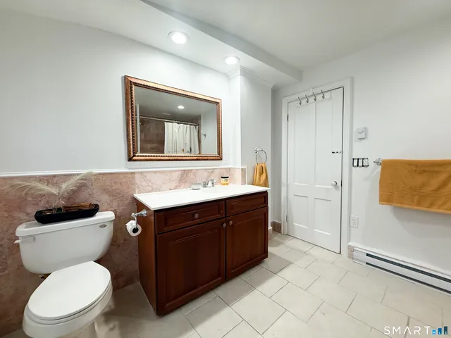 a bathroom with a toilet sink and mirror
