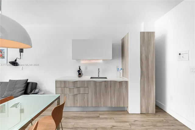 a kitchen with stainless steel appliances a table and chairs in it