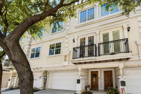 a front view of a house with a tree