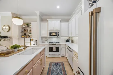 a kitchen with stainless steel appliances granite countertop a sink a stove and a refrigerator