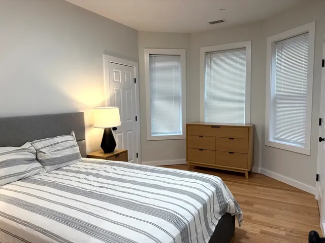a bedroom with a bed and wooden floor