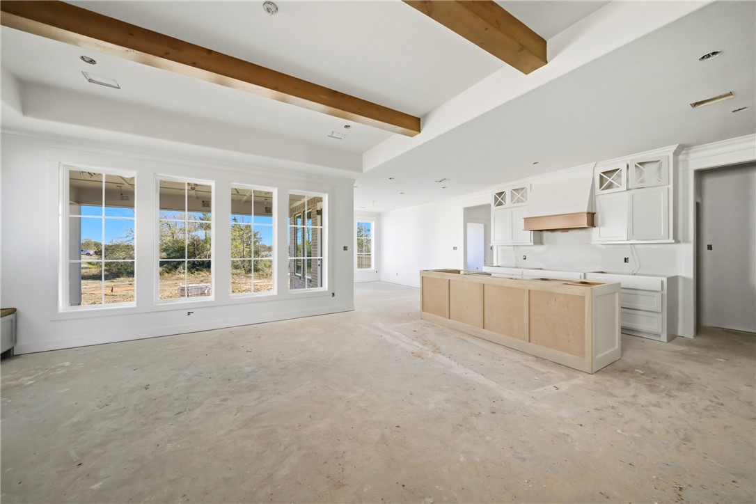 5103 Booth Falls Trail Bryan, TX 77802 - Photo 4 of 18 View of living room with large picture windows, beams, and open kitchen layout.