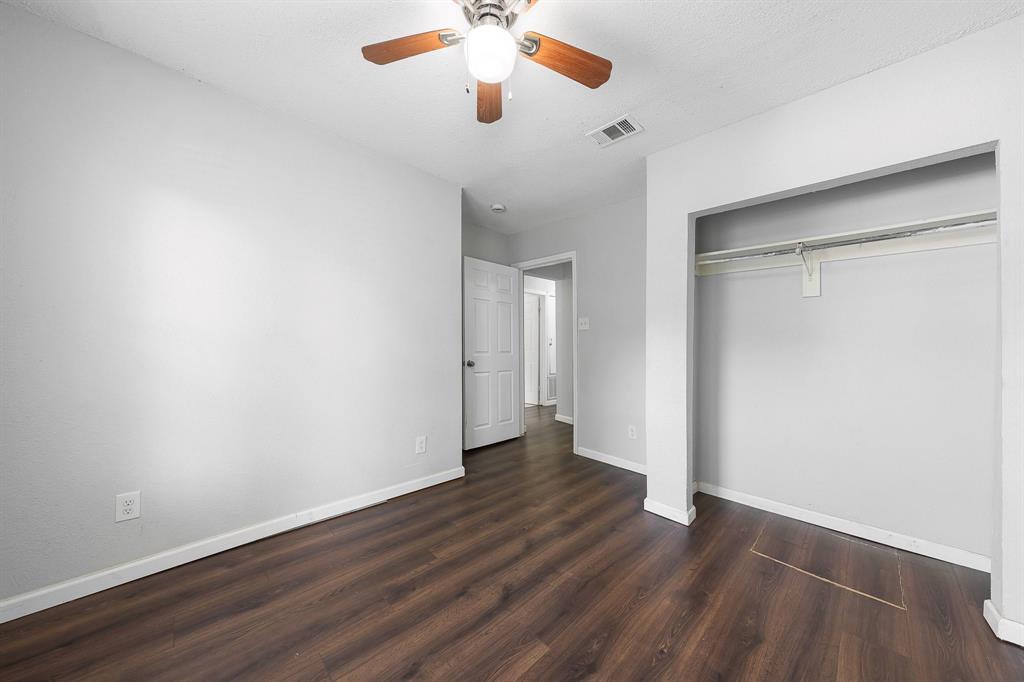 1330 Fordham Road Dallas, TX 75216 - Photo 22 of 37 Interior space featuring wood-finish flooring, light gray walls, white trim, and an open closet with a hanging rod