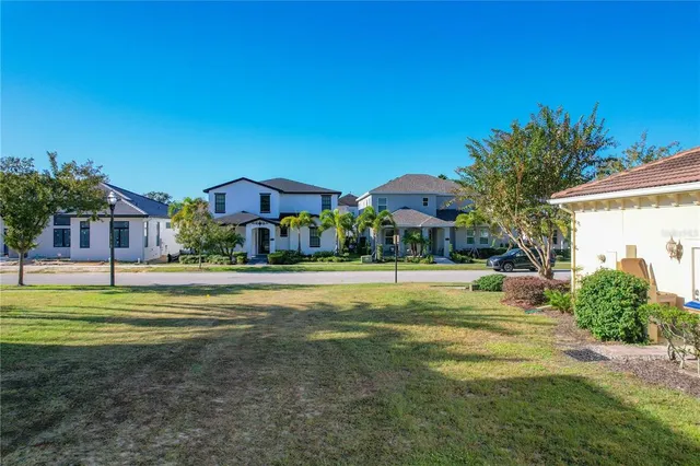 a view of a big house with a big yard and palm trees