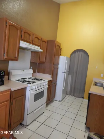 a kitchen with a stove top oven cabinets and a refrigerator