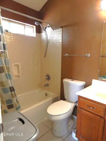 a white toilet sitting next to a bath tub and a shower