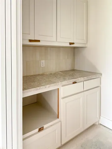 a kitchen with granite countertop white cabinets and a sink