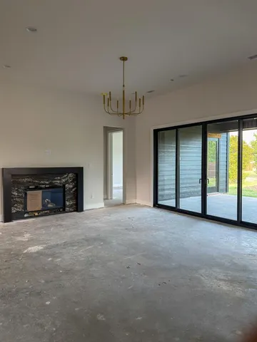 a view of an empty room with a fireplace and a window