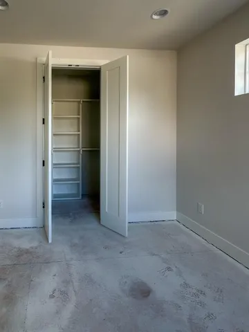 an empty room with a closet and cabinet
