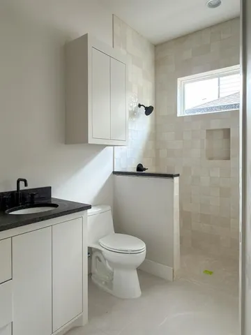 a white toilet sitting next to a bathroom sink
