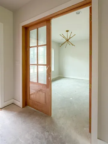 an empty room with windows and a ceiling fan