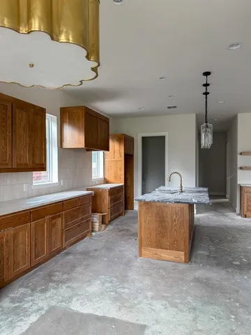 a large kitchen with stainless steel appliances wooden cabinets a sink and a counter top space