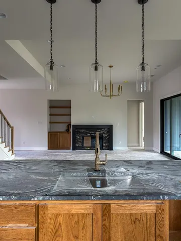 a view of a kitchen with stainless steel appliances granite countertop a sink and a wooden floor