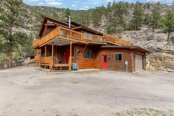 a view of a house with a yard and large tree