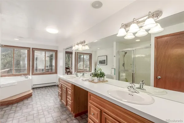 a spacious bathroom with a bathtub sink and mirror