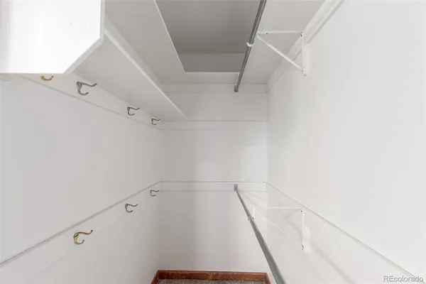 a view of walk in closet with empty racks