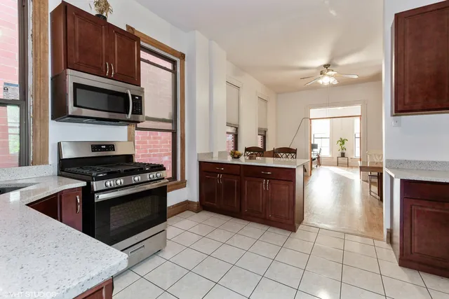 a kitchen with granite countertop a stove top oven and cabinets
