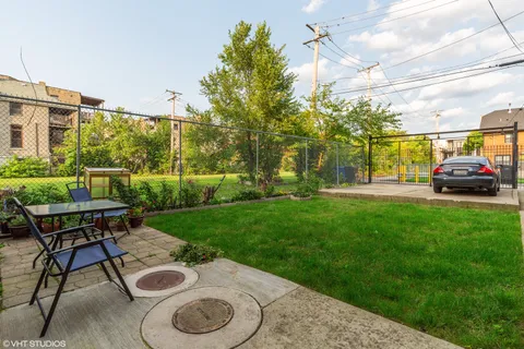 a view of a backyard with table and chairs and a barbeque with potted plants