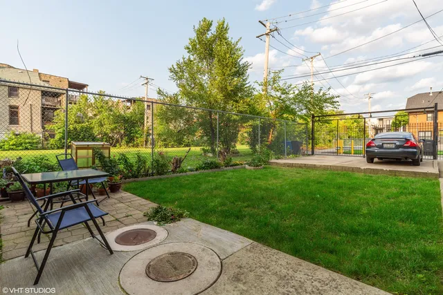 a view of a backyard with table and chairs and a barbeque with potted plants