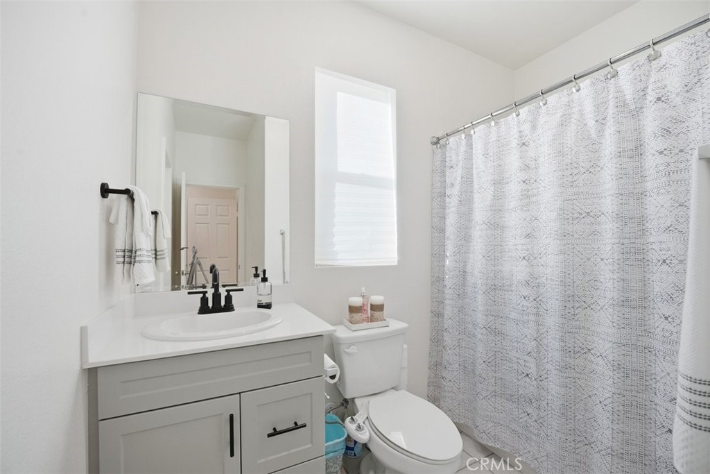 7608 Citrusmoon Court Riverside, CA 92507 - Photo 7 of 25 a bathroom with a sink a toilet and a mirror