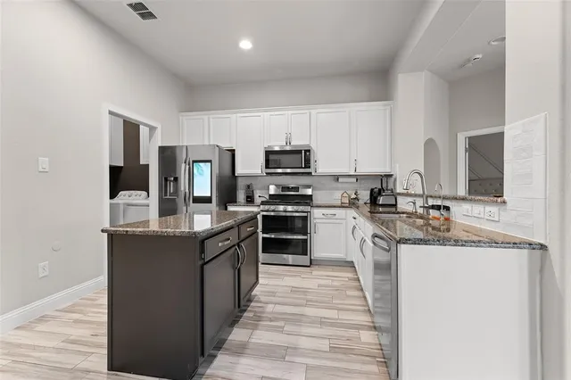 a kitchen with stainless steel appliances granite countertop a stove top oven a sink and dishwasher