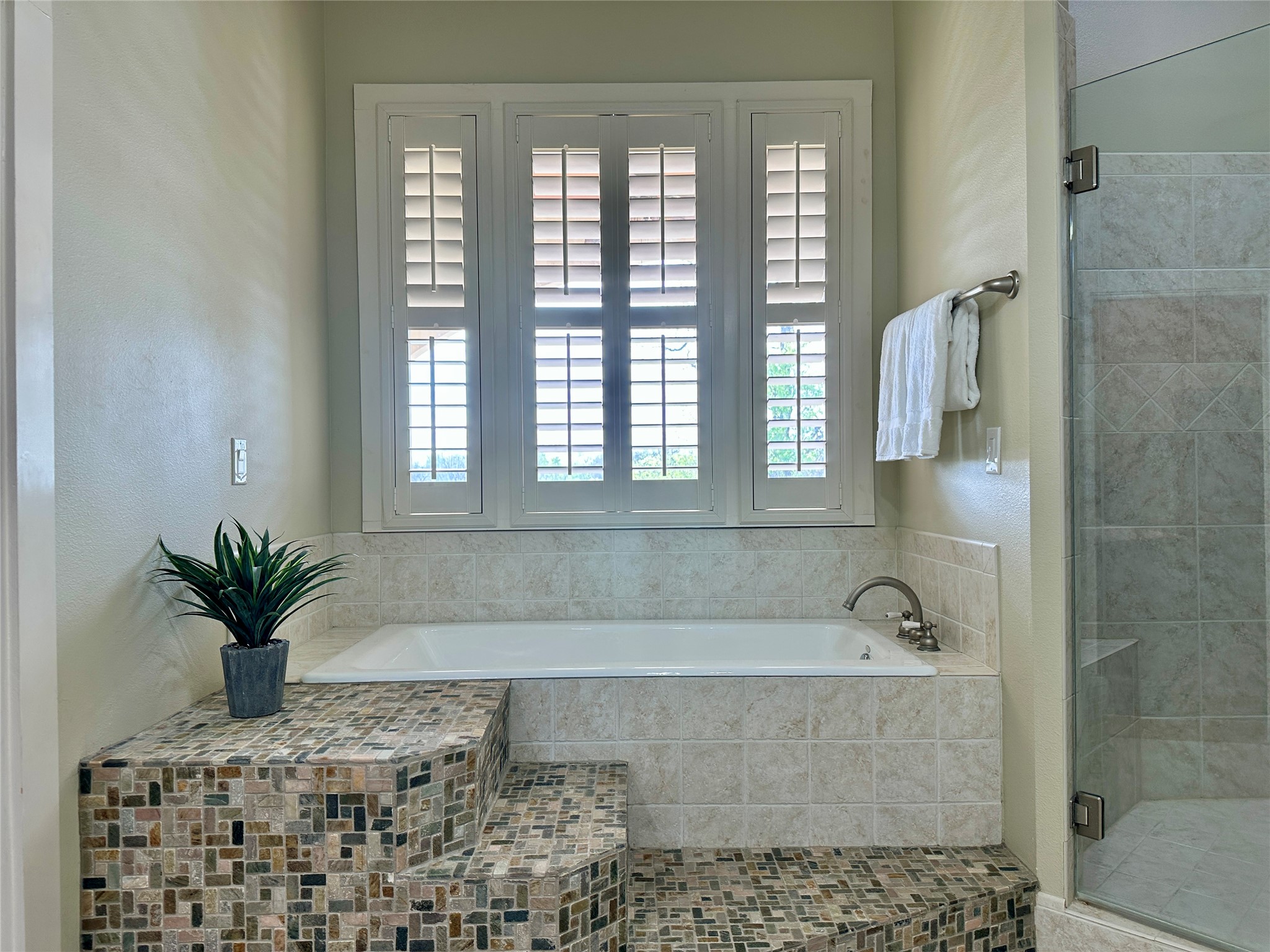 802 Main Street Bastrop, TX 78602 - Photo 25 of 37 a bathroom with a granite countertop a bathtub a window and a shower