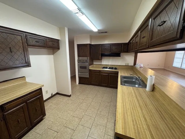 a kitchen with stainless steel appliances granite countertop a refrigerator and a stove