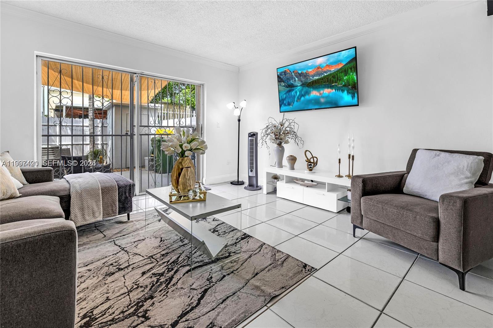 1675 West 57th Street, Unit 514 Hialeah, FL 33012 - Photo 14 of 26 a living room with furniture a rug and a floor to ceiling window