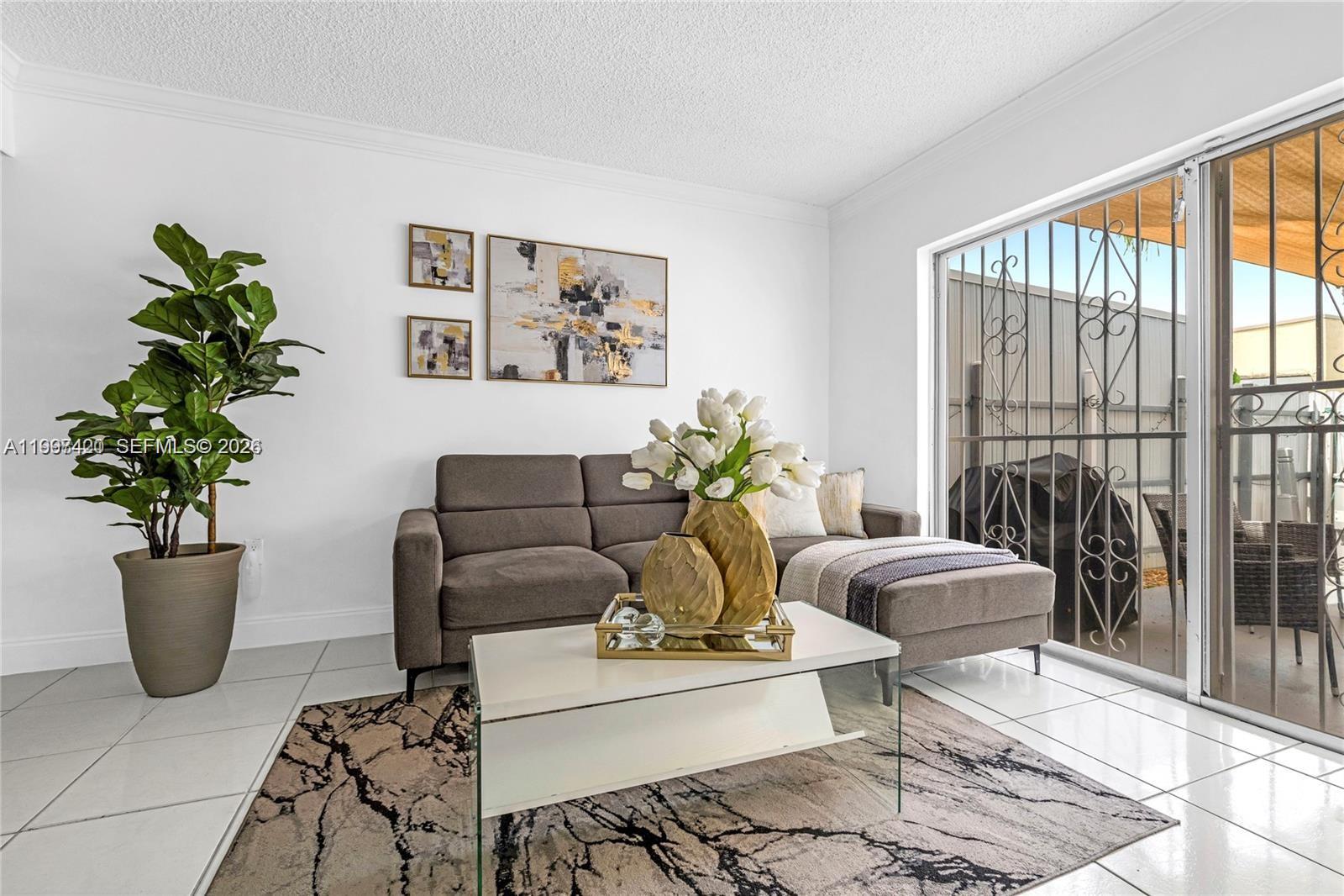 1675 West 57th Street, Unit 514 Hialeah, FL 33012 - Photo 18 of 26 a living room with furniture and a potted plant