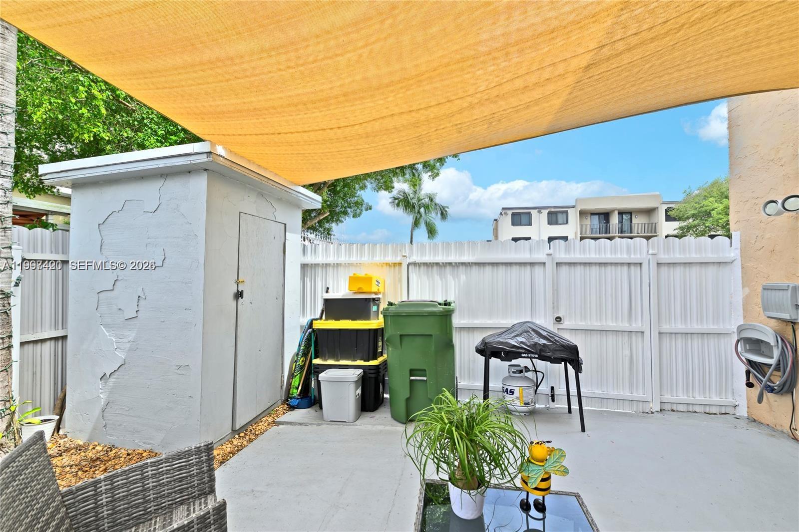 1675 West 57th Street, Unit 514 Hialeah, FL 33012 - Photo 20 of 26 a view of a chair and table in backyard of the house